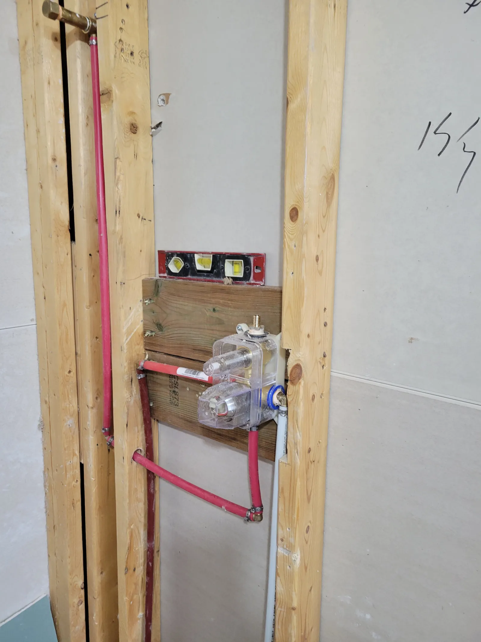 New PEX plumbing and a pressure-balanced shower valve roughed in on the framed shower wall
