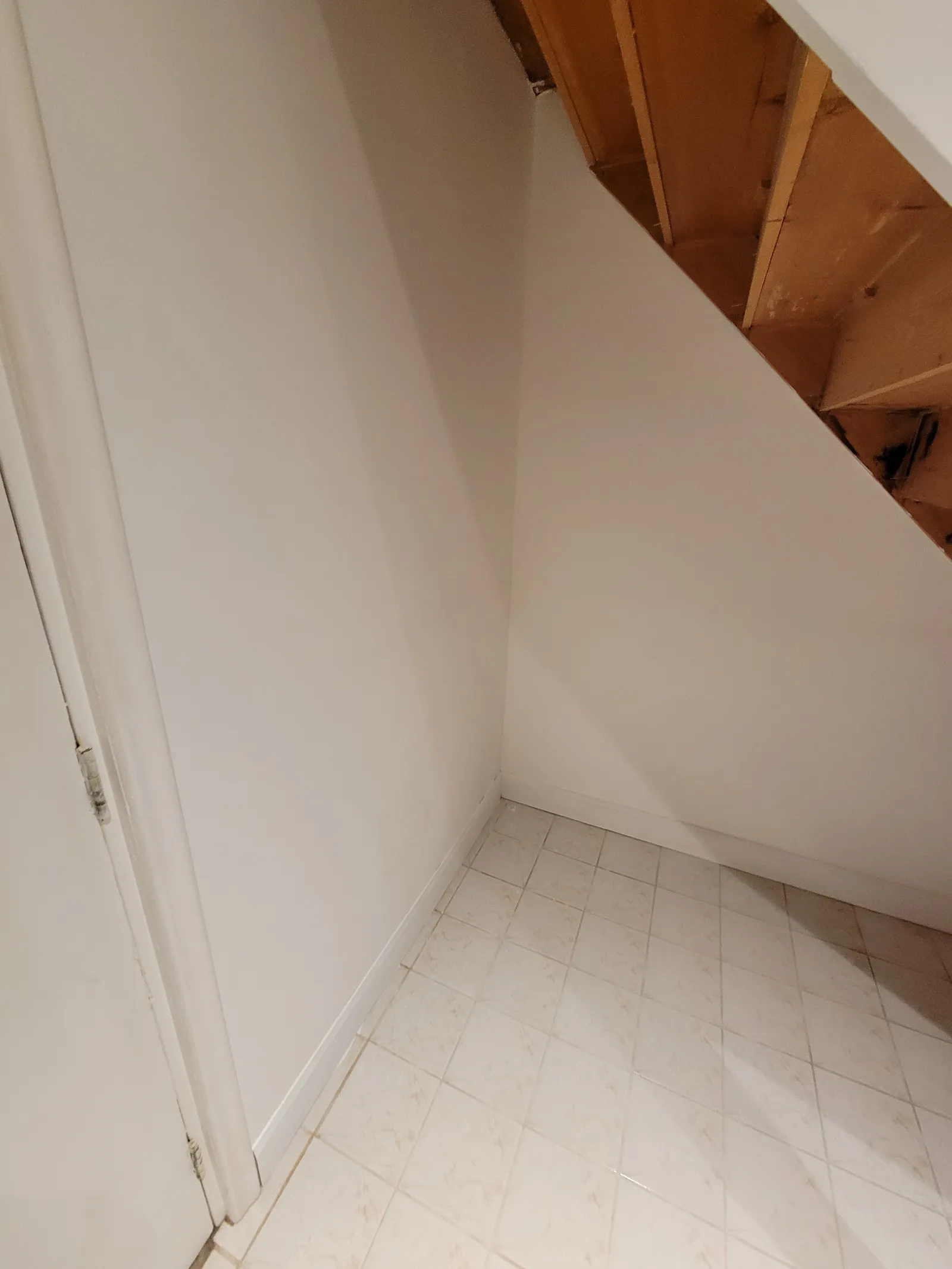 Second angle of the finished drywall repair in East Gwillimbury, showing the clean line where the wall meets the wood stringer and tile