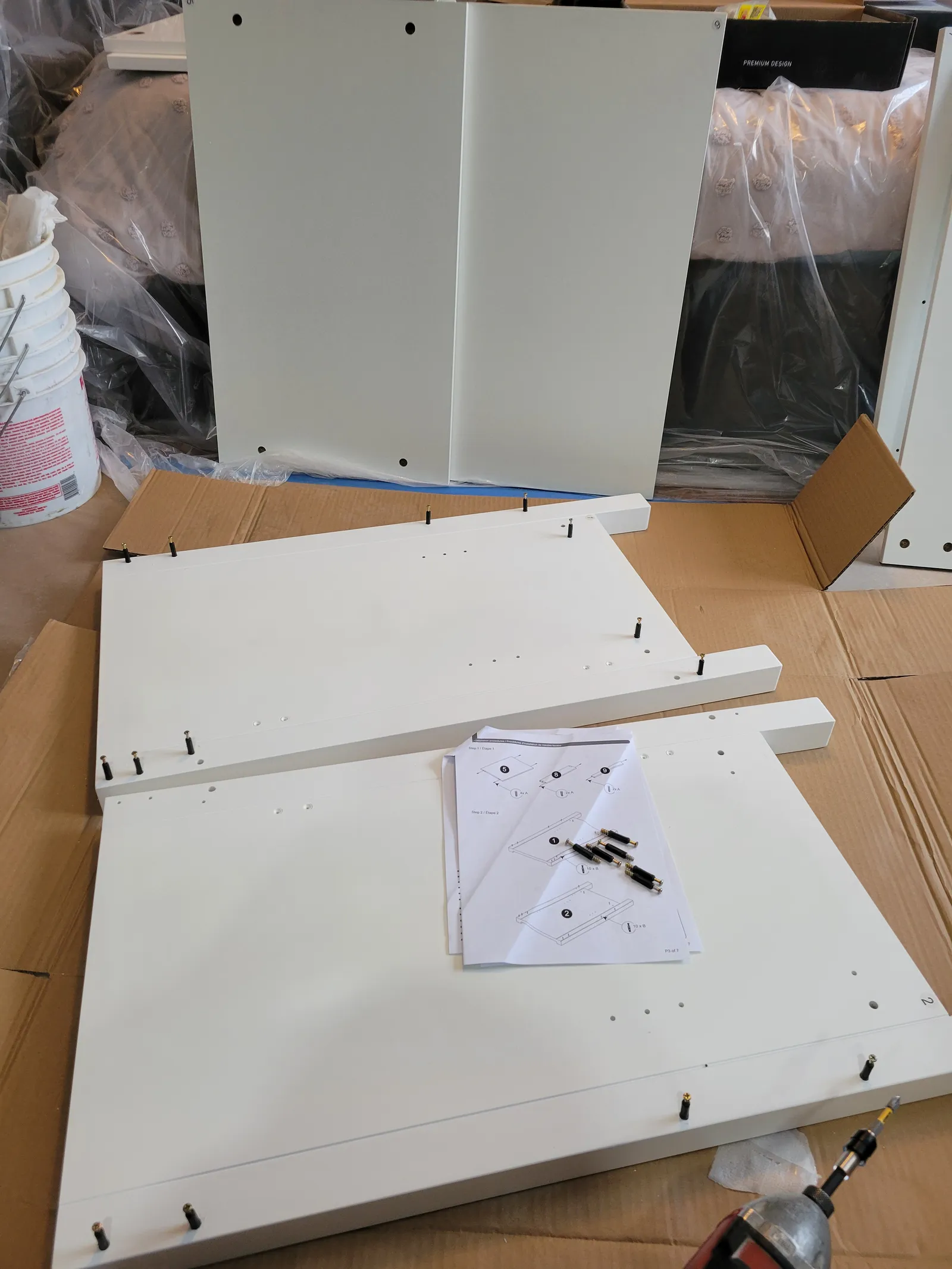 Flat-pack IKEA kitchen cabinet panels and hardware laid out for assembly in King City