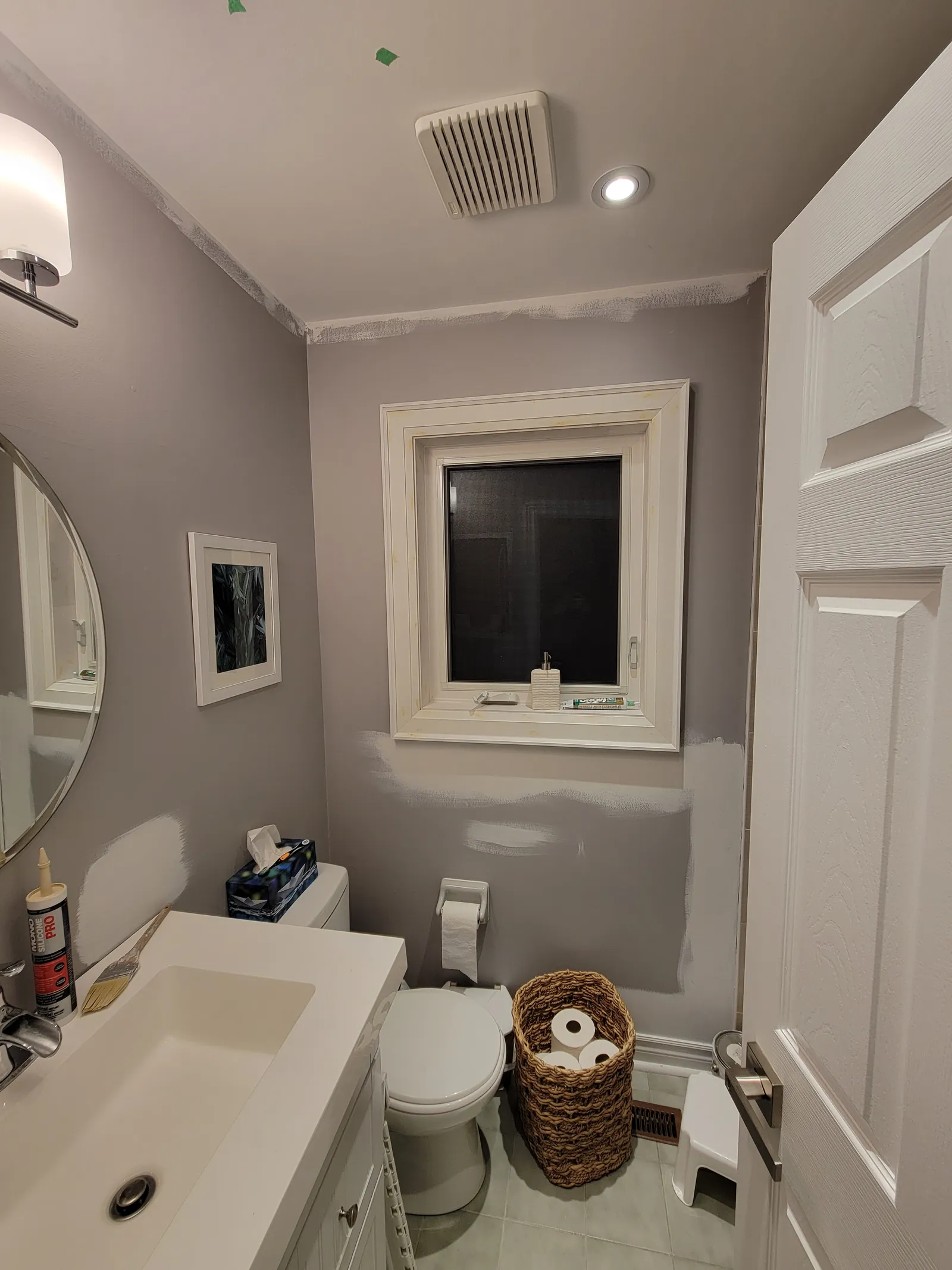 Finished greige bathroom corner in Bradford with white-trimmed window, framed art and recessed lighting