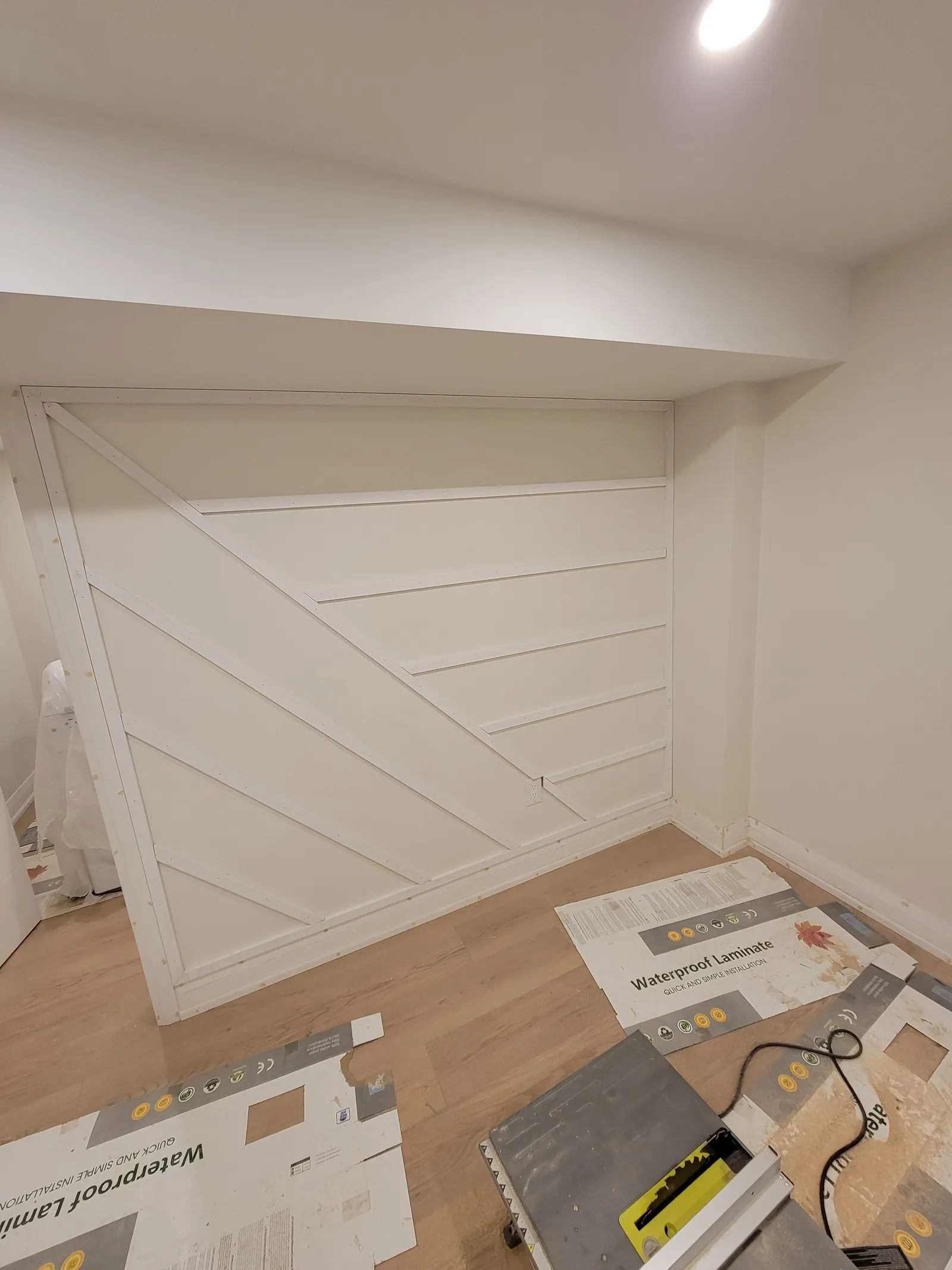 Panel-and-batten feature wall being built into an alcove in Aurora with a diagonal geometric MDF pattern