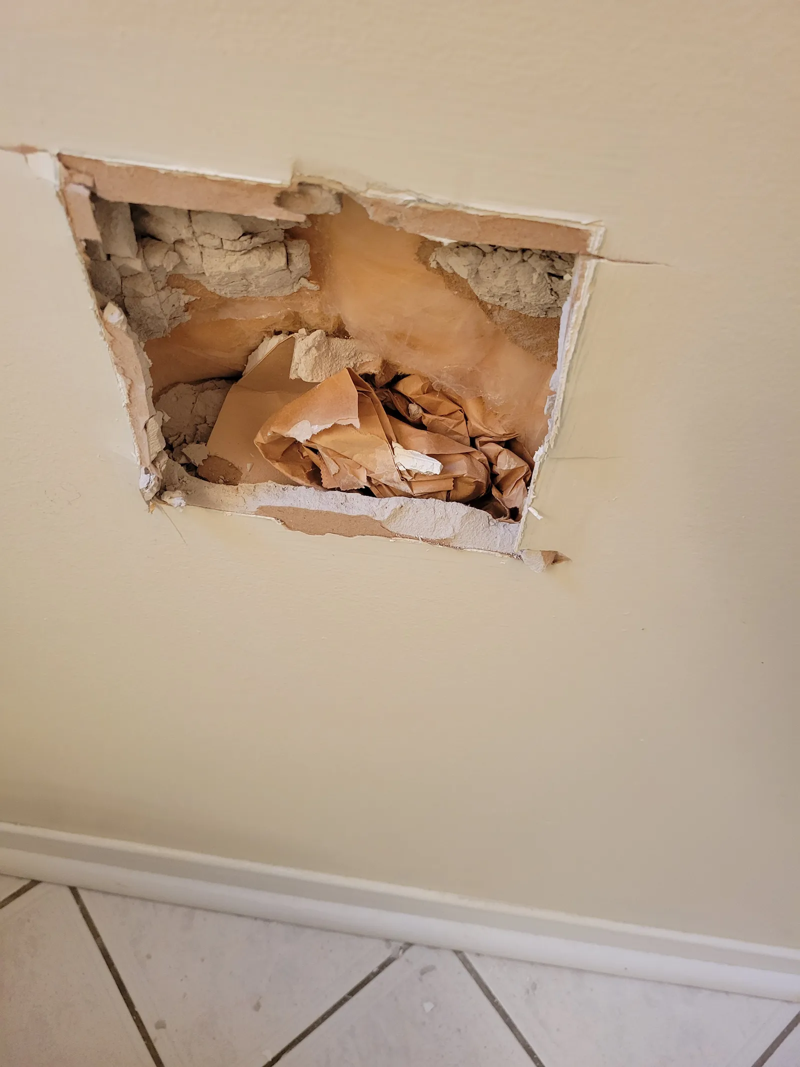 Powder room in Newmarket mid-renovation with a square section of wall opened up next to the door trim