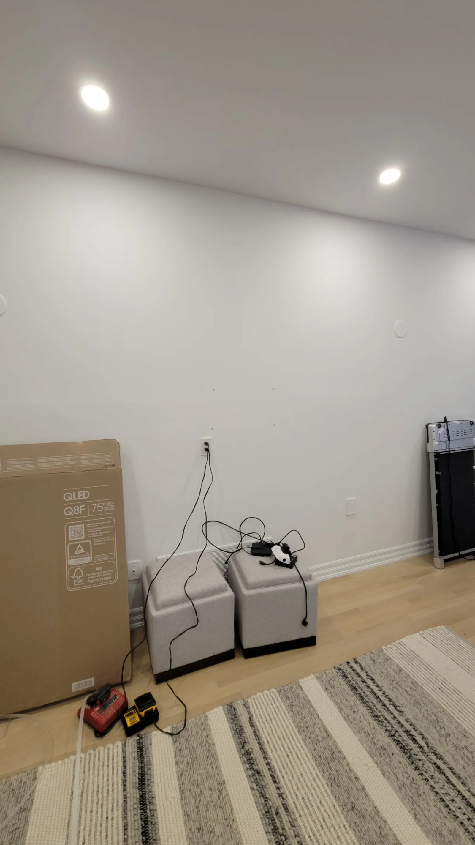 Blank living room wall in Newmarket before TV mounting, with the 75-inch QLED still in the box