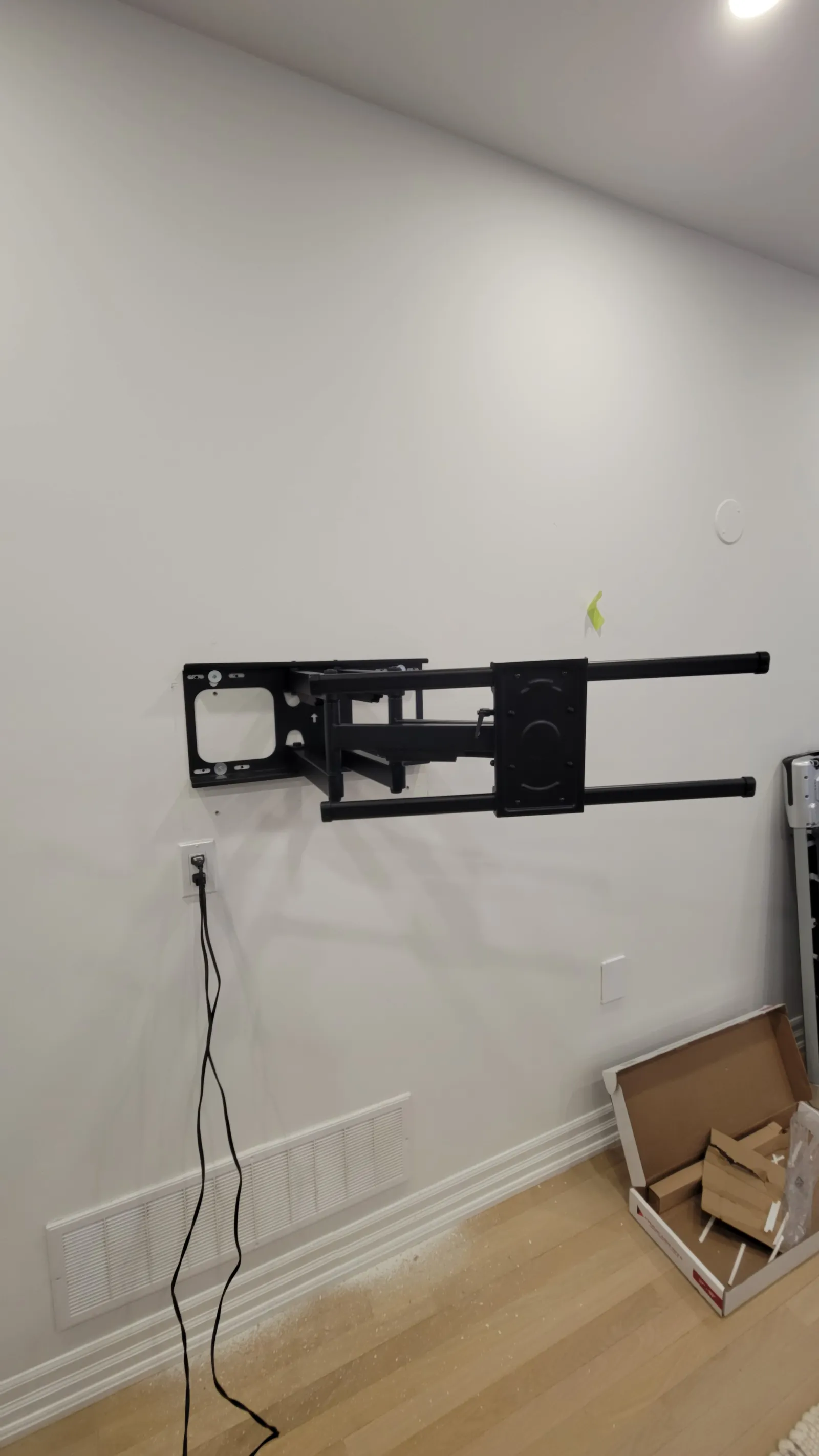 Articulating TV wall-mount bracket bolted level into the studs in a Stouffville living room, cables routed to the outlet